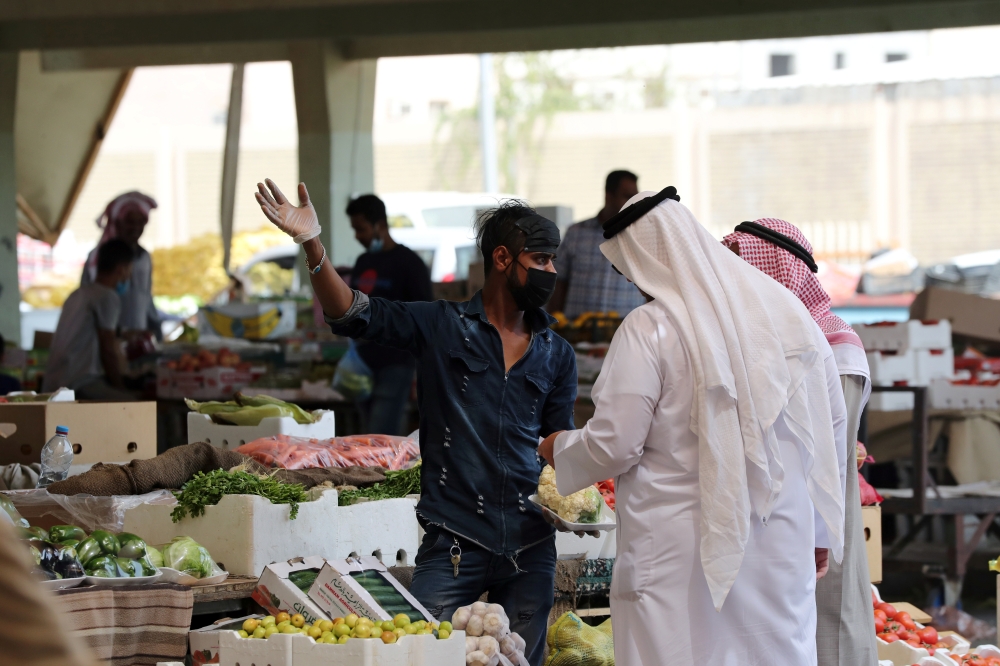 A man wearing a protective face mask sells fruit at a market, after Saudi Arabia imposed a temporary lockdown on the province of Qatif following the spread of coronavirus, in Qatif, Saudi Arabia March 9, 2020. Reuters
 