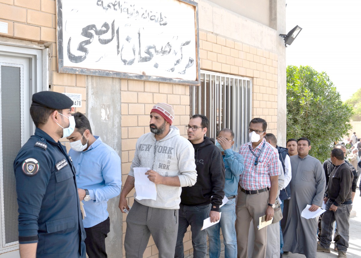 Expatriates are seen in line as they need to take a coronavirus clearance certificate, after returning from vacations, following the outbreak of the virus, at a health clinic in Subhan, Kuwait March 9, 2020. Reuters/Stephanie McGehee