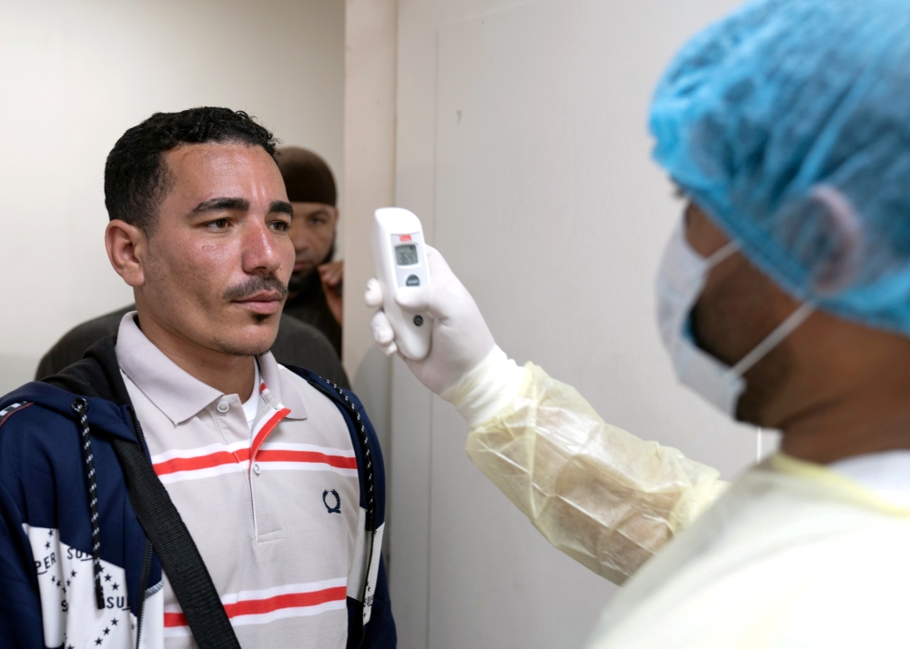 FILE PHOTO: An expatriate (L) takes a coronavirus temperature test, after returning from a vacation, following the outbreak of the virus, at a health clinic in Subhan, Kuwait March 9, 2020. REUTERS/Stephanie McGehee/File Photo