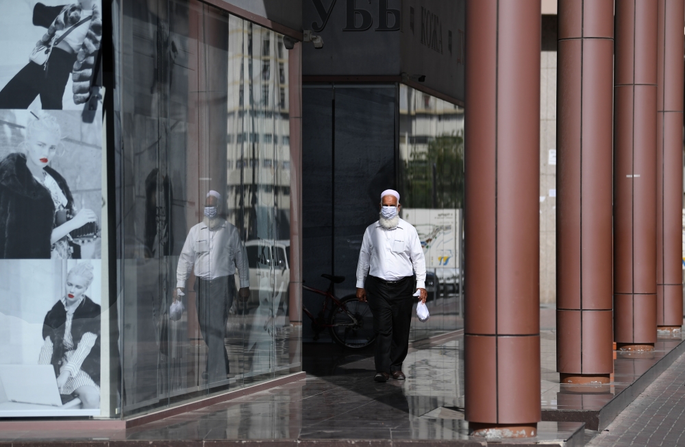 A man wearing a protective mask walks down the street in Dubai on March 18, 2020 amidst the coronavirus COVID-19 pandemic. / AFP / KARIM SAHIB