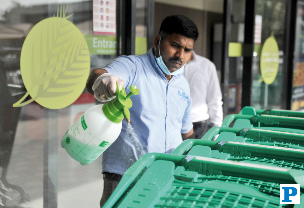 A staff sanitising trolleys at Al Meera Hypermarket. Pic: Baher Amin/The Peninsula 