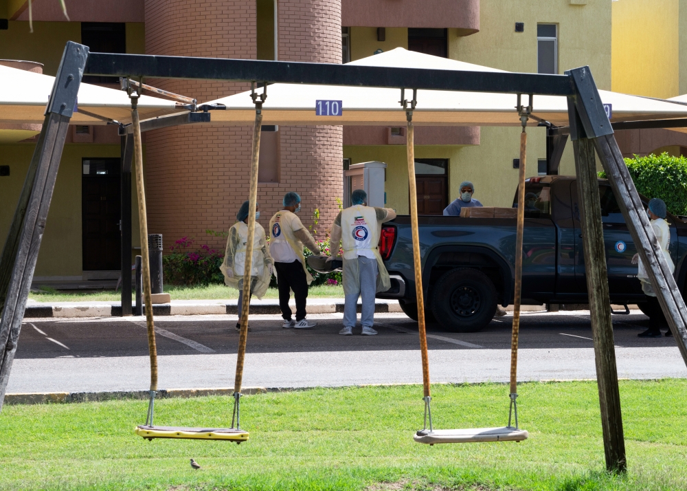 Red Crescent members deliver meals for isolated people following coronavirus disease (COVID-19) outbreak at Khairan Resort, used as a quarantine centre, in Khairan, Kuwait March 19, 2020. Reuters/Stephanie McGehee