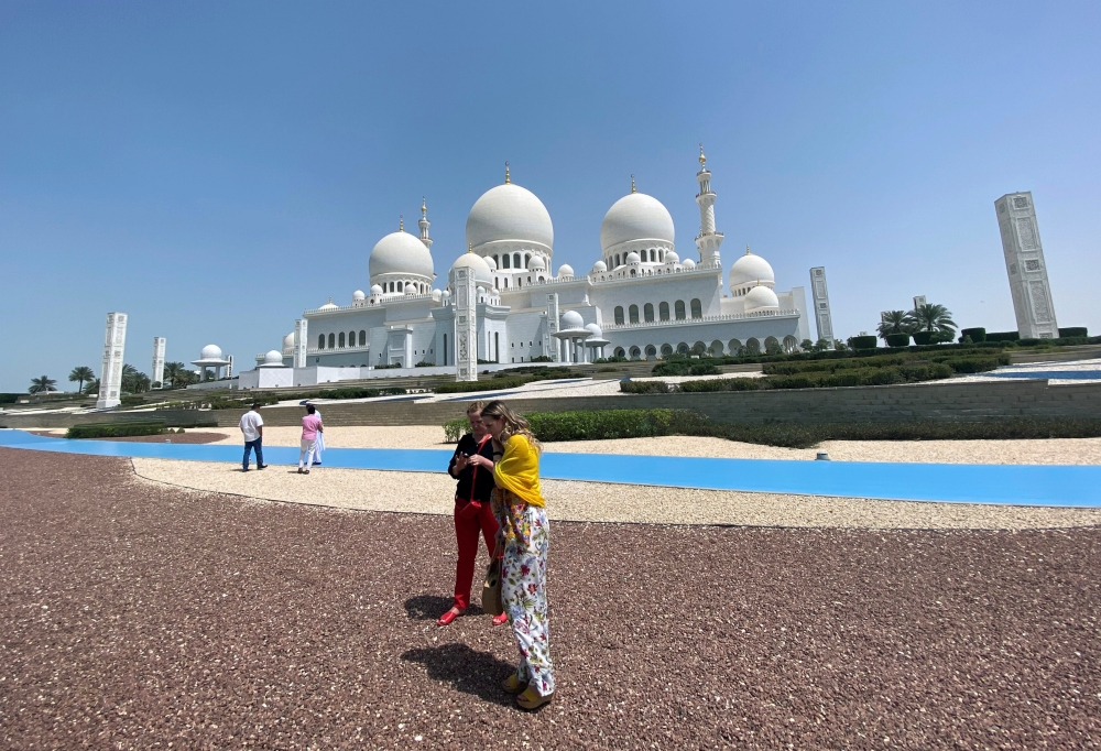 Tourists are seen outside empty Sheikh Zayed Mosque, as Friday prayers were suspended following the spread of the coronavirus disease (COVID-19), in Abu Dhabi, United Arab Emirates, March 20, 2020. Reuters/Satish Kumar
 