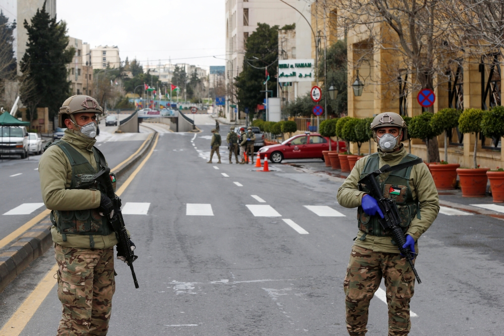 Jordanian army members stand guard at a check point after the start of a nationwide curfew, amid concerns over the coronavirus disease (COVID-19) spread, in Amman, Jordan March 21, 2020. REUTERS/Muhammad Hamed
