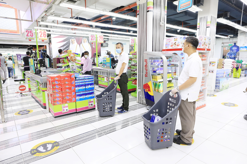 Customers stand at a safe distance on the markings at Ansar Gallery Airport Road Branch.