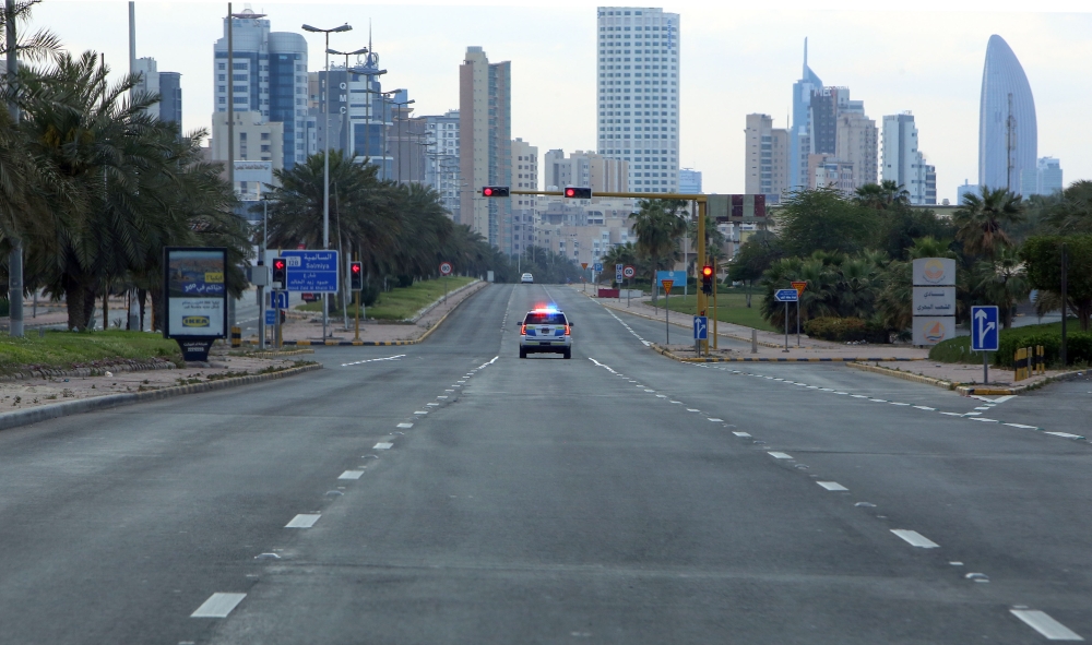 A Kuwaiti police car patrols deserted streets in Kuwait city, on March 23, 2020, a day after authorities declared a nationwide curfew amid the COVID-19 coronavirus pandemic. / AFP / YASSER AL-ZAYYAT