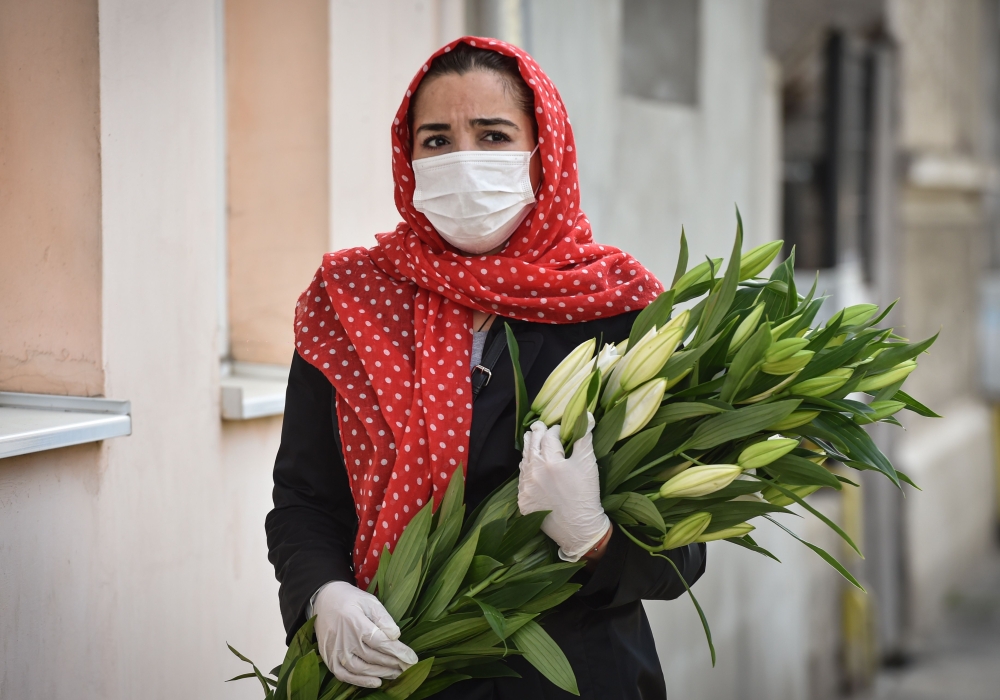 A woman wearing protection gloves and mask. (AFP / Daniel MIHAILESCU)