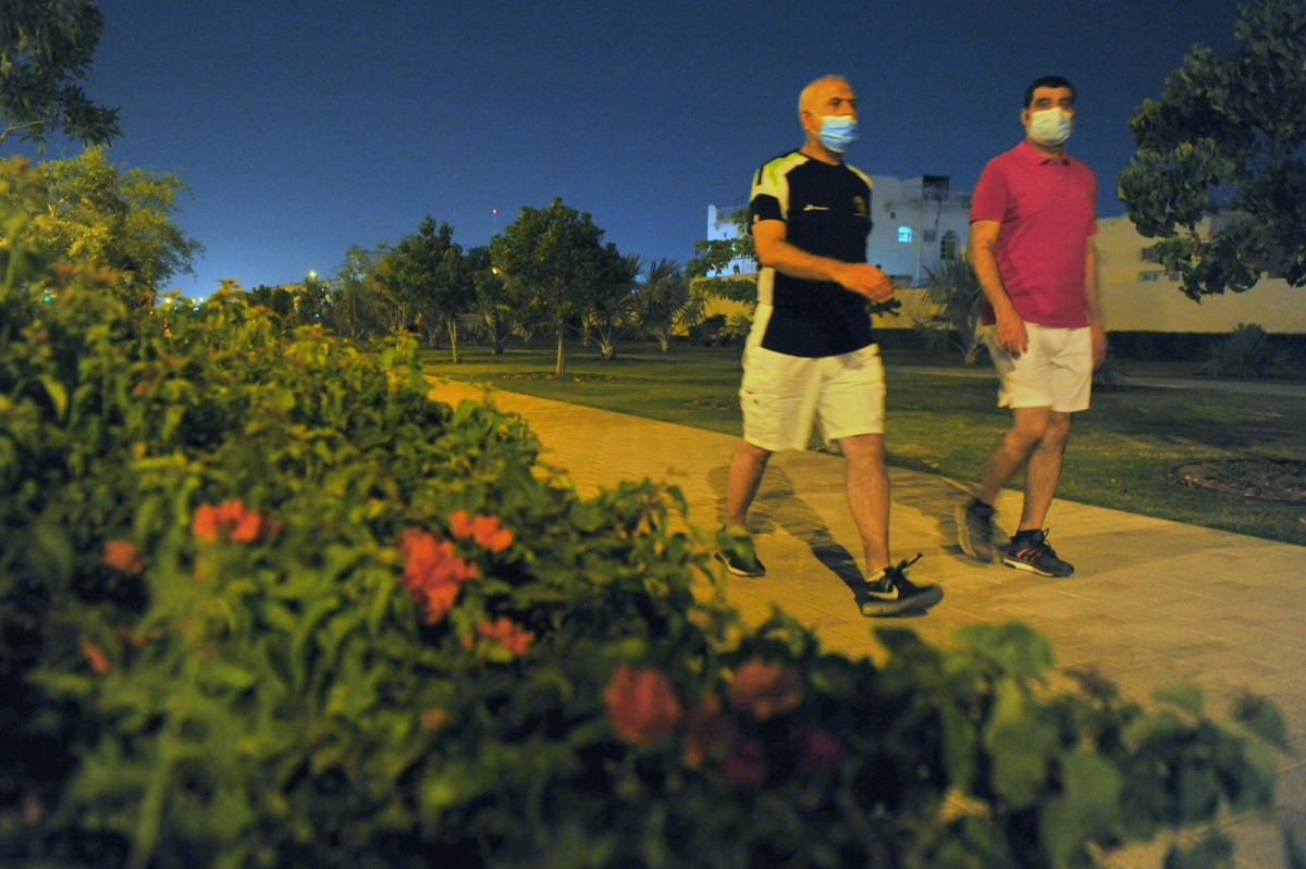 Men wearing protective face masks walk on a jogging track in Doha's Old Airport area. Wearing face masks in public has been made mandatory by the government. Pic: Baher Amin/The Peninsula