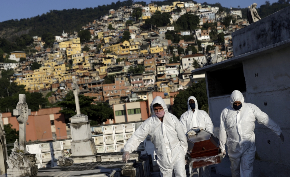 Gravediggers carry the coffin of Avelino Fernandes Filho, 74, who passed away from the coronavirus disease (COVID-19), during his funeral in Rio de Janeiro, Brazil, May 18, 2020. REUTERS/Ricardo Moraes