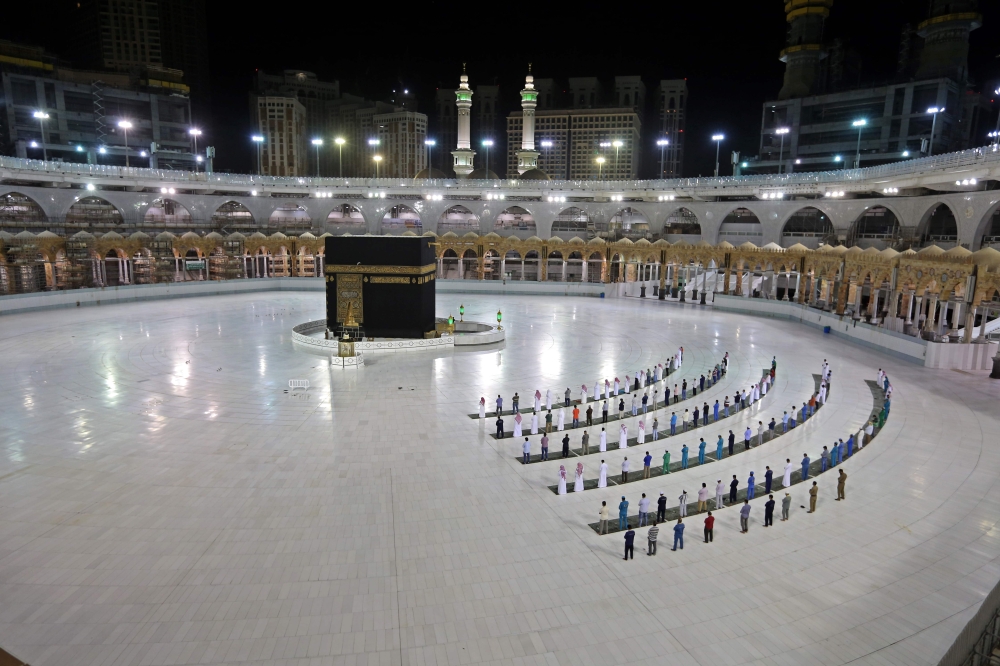 A picture taken June 23, 2020 shows a few worshippers performing al-Fajr prayer at the Kaaba, at the Grand Mosque complex in Saudi Arabia's holy city of Mecca. AFP / STR