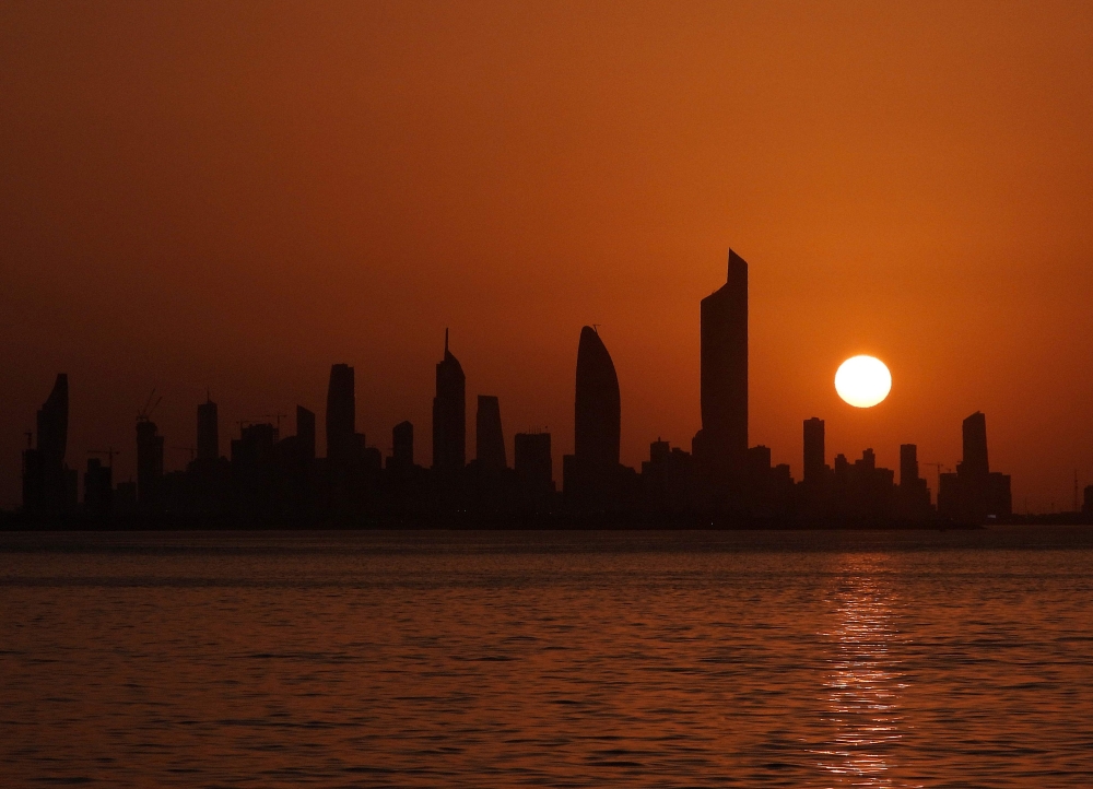 The sun sets behind the skyline of Kuwait City on June 25, 2020. AFP / YASSER AL-ZAYYAT