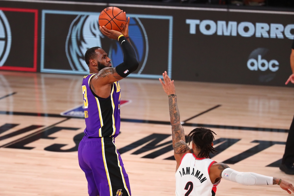 Aug 22, 2020; Lake Buena Vista, Florida, USA; Los Angeles Lakers forward LeBron James (23) shoots a three pointer against Portland Trail Blazers guard Gary Trent Jr. (2) in the first half in game three of the first round of the 2020 NBA Playoffs at Advent