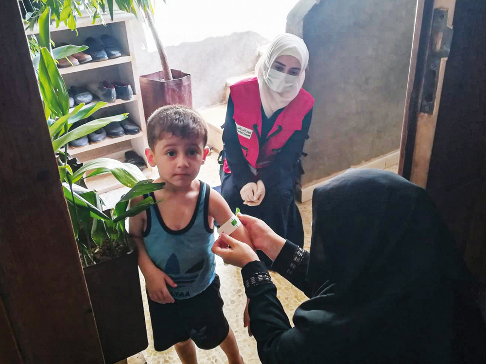 Representatives of QRCS conducting a medial test on a child under a project to support life-saving therapeutic and preventive nutrition services, in Syria.