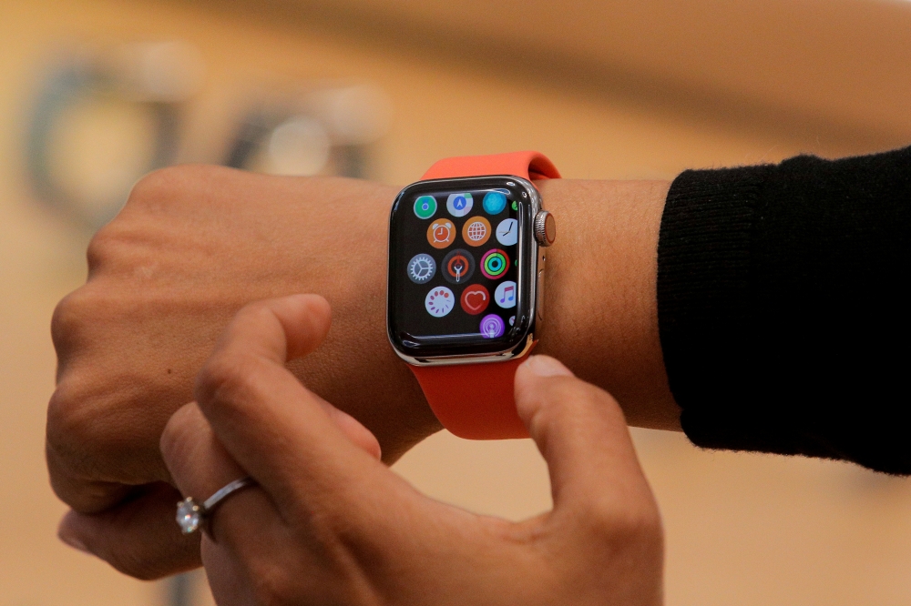 FILE PHOTO: An Apple Store employee shows the new Series 5 Apple Watch during the preview of the redesigned and reimagined Apple Fifth Avenue store in New York, U.S., September 19, 2019. REUTERS/Brendan McDermid