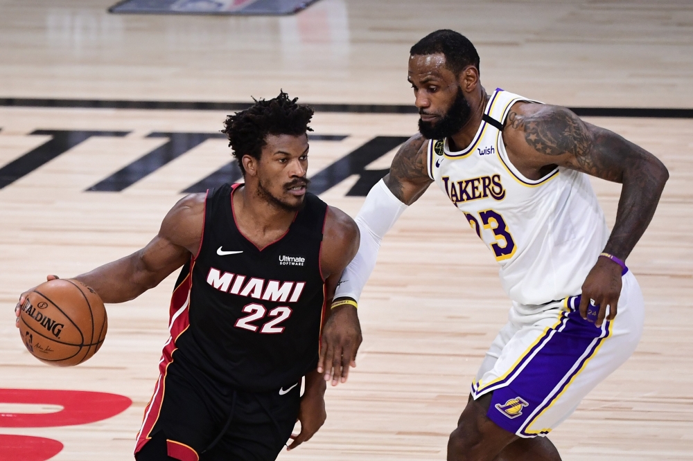 LAKE BUENA VISTA, FLORIDA - OCTOBER 04: Jimmy Butler #22 of the Miami Heat dribbles against LeBron James #23 of the Los Angeles Lakers during the second half in Game Three of the 2020 NBA Finals at AdventHealth Arena at ESPN Wide World Of Sports Complex o