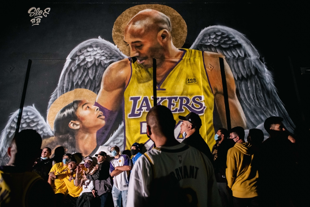 Lakers fans stand in line to celebrate in front of a mural of Kobe Bryant and his daughter Gianna Bryant on October 11, 2020 in Los Angeles, California. People gathered to celebrate after the Los Angeles Lakers defeated the Miami Heat in Game 6 of the NBA