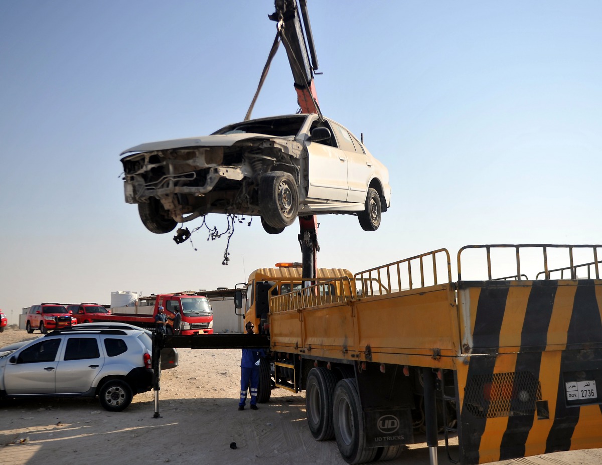 An abandoned car being loaded onto a truck, in Al Sheehaniya Municipality, yesterday. Photo credit: Abdul Basit/ The Peninsula 