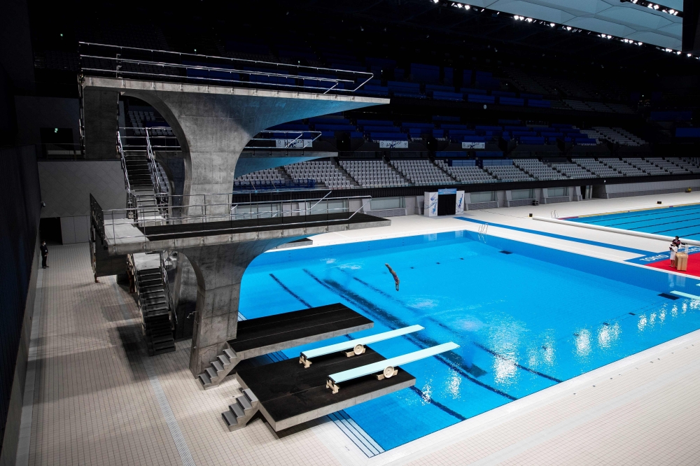 A diver demonstrates during the opening ceremony of Tokyo Aquatics Centre, a venue for swimming, diving and artistic swimming of the 2020 Tokyo Olympics and Paralympics Games, in Tokyo on October 24, 2020. / AFP / Behrouz Mehri