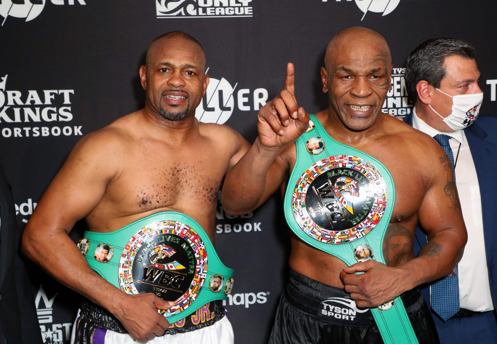 This handout images courtesy of Getty Images for Triller shows Roy Jones Jr. (L) and Mike Tyson celebrate their split draw during Mike Tyson vs Roy Jones Jr. presented by Triller at Staples Center on November 28, 2020 in Los Angeles, California. AFP PHOTO