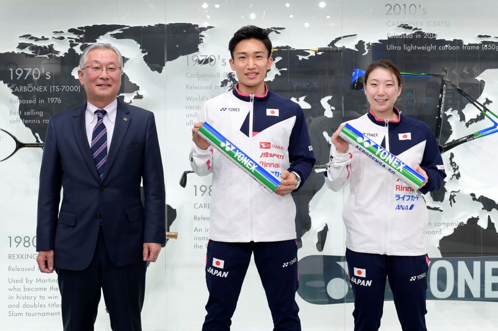 This handout picture released by Yonex on December 9, 2020 shows Japan's badminton world number one Kento Momota (C) poses at a press conference with other participants in Tokyo, after announcing his long-awaited return to competition, nearly a year after