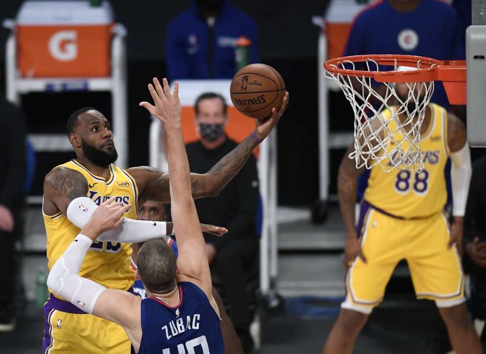 LeBron James #23 of the Los Angeles Lakers scores on a layup over Ivica Zubac #40 of the LA Clippers during a 116-109 LA Clippers win in the season opening game at Staples Center on December 22, 2020 in Los Angeles, California.   Harry How//AFP  
