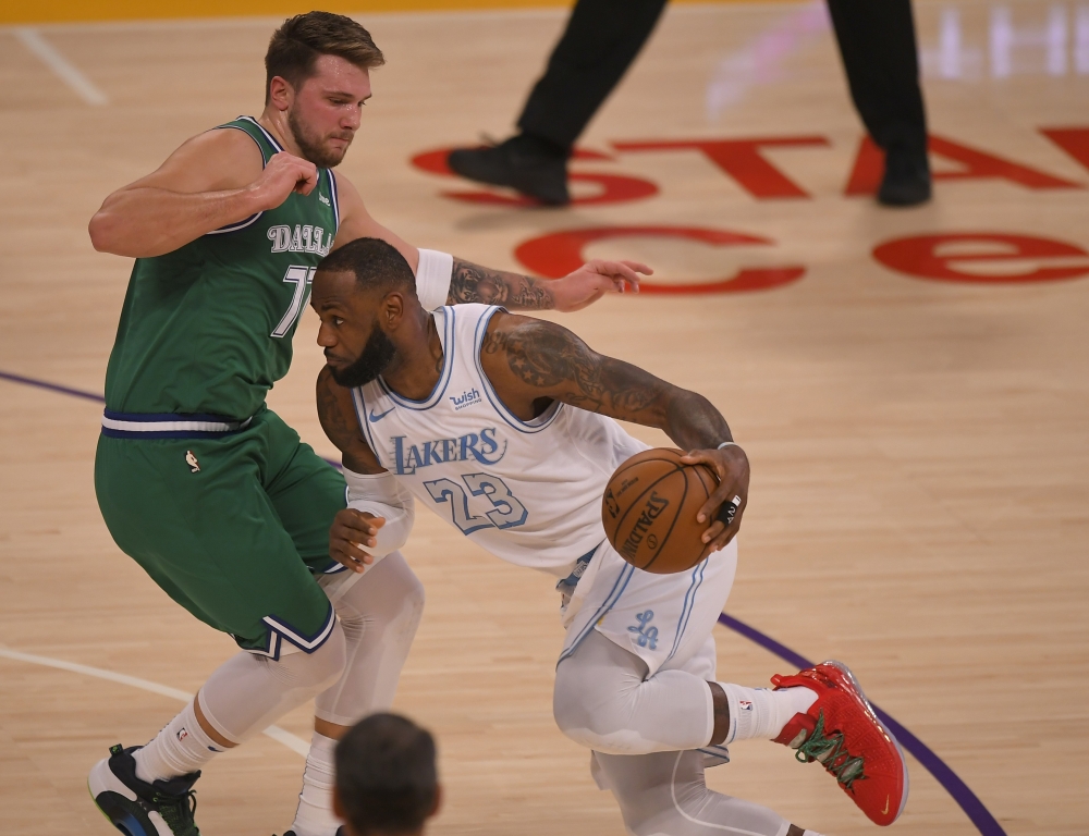 Luka Doncic #77 of the Dallas Mavericks guards LeBron James #23 of the Los Angeles Lakers in the first half at Staples Center on December 25, 2020 in Los Angeles, California. John McCoy/AFP
