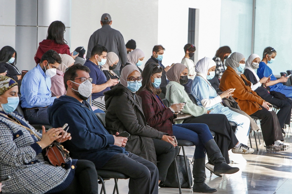 People wait for their turn to be vaccinated for COVID-19 coronavirus at the make-shift vaccination centre erected at the Kuwait International Fairground in the Mishref suburb south of Kuwait City on December 29, 2020. / AFP / YASSER AL-ZAYYAT