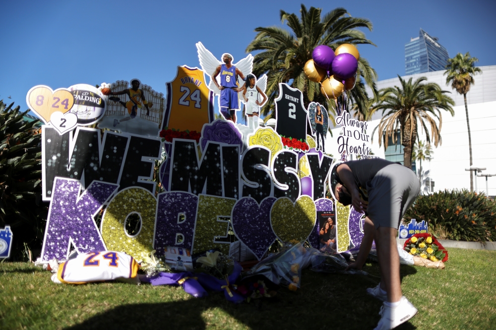 A fan pays tribute to late Kobe Bryant, who perished one year ago alongside his daughter and seven others when their helicopter crashed into a hillside near Los Angeles, gather outside the Staples Center in Los Angeles, California, U.S., January 26, 2021.