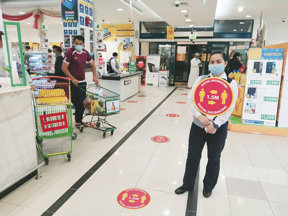 A Lulu officer guiding visitors to maintain social distancing. 