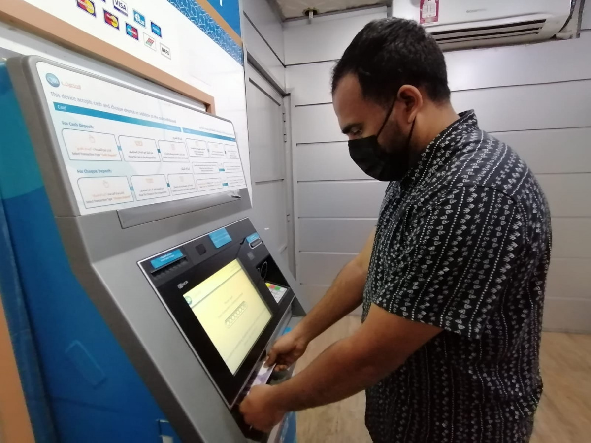 A resident depositing new currency notes using an ATM in Old Airport. Photo: Salim Matramkot / The Peninsula