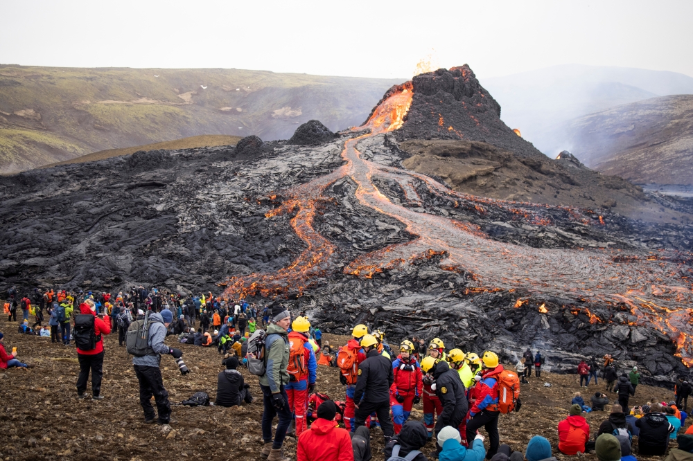 People gather at the volcanic site on the Reykjanes Peninsula following Friday's eruption in Iceland, March 21, 2021. Picture taken March 21, 2021. REUTERS/Cat Gundry-Beck 
