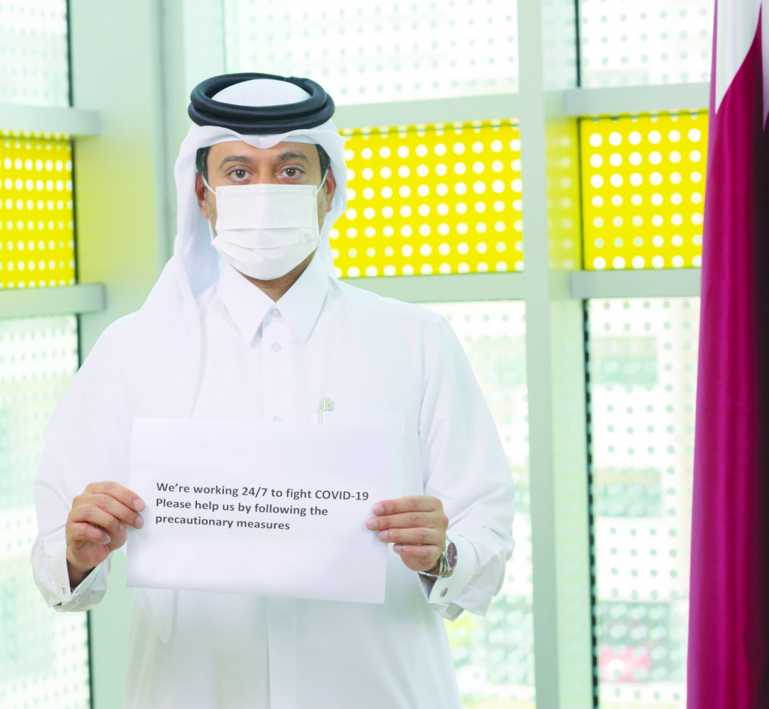 Co-chair of the National Epidemic Preparation Committee Dr. Hamad Al Rumaihi holding a placard, requesting the public to follow preventive measures. 