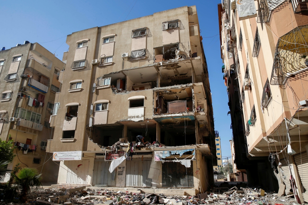 A Palestinian man inspects a damaged apartment in the aftermath of Israeli air strikes in Gaza City May 15, 2021. Reuters/Mohammed Salem
