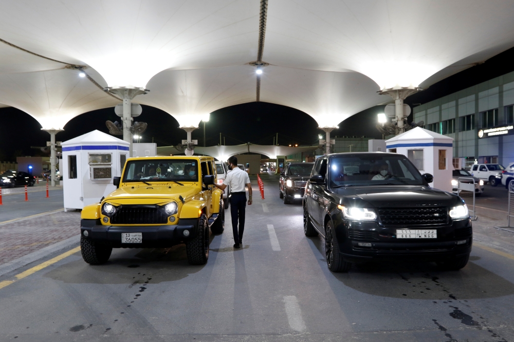 A customs officer checks cars of Saudi nationals as they enter Bahrain, after Saudi authorities lift the travel ban on its citizens after fourteen months due to Coronavirus (COVID-19) restrictions, at King Fahad Causeway, Bahrain, May 17, 2021. Reuters/Ha