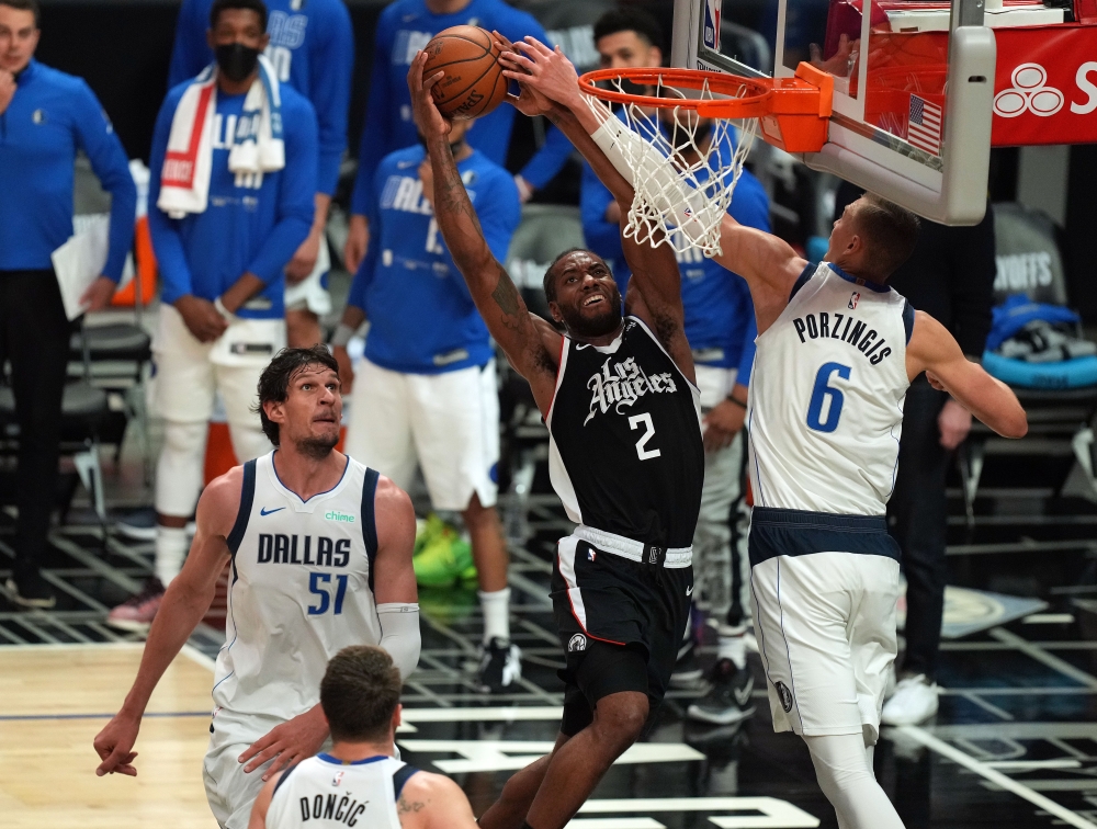 Los Angeles Clippers forward Kawhi Leonard (2) moves in for a basket against Dallas Mavericks center Kristaps Porzingis (6) and center Boban Marjanovic (51) during the second half in game seven of the first round of the 2021 NBA Playoffs. at Staples Cente