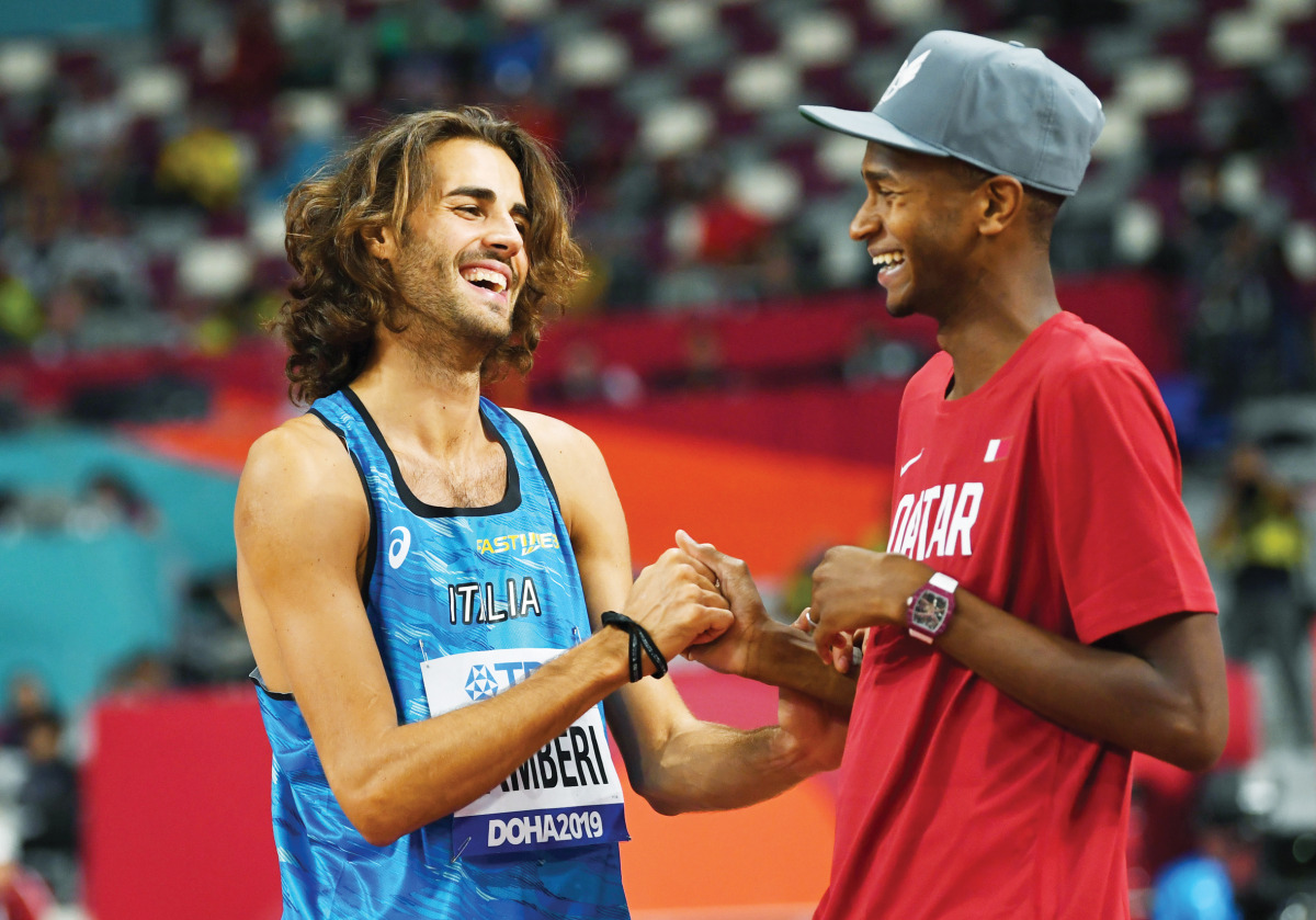 Qatar's Mutaz Essa Barshim talks with Italy's Gianmarco Tamberi during the World Athletics Championships in Doha in this file photo.