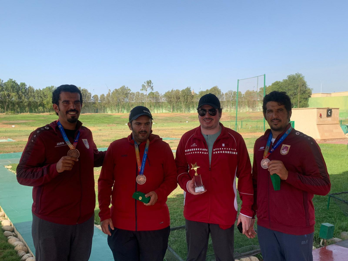 Qatari shooters pose for a group photo after winning bronze medal in team trap event.