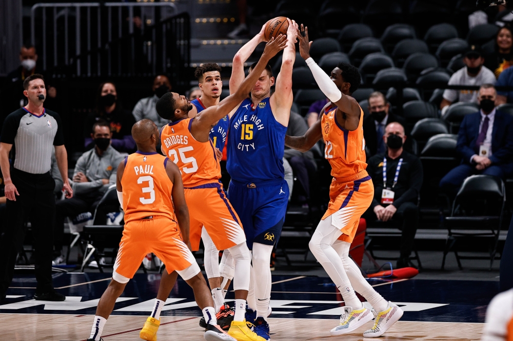 Denver Nuggets center Nikola Jokic (15) is defended by Phoenix Suns center Deandre Ayton (22) and forward Mikal Bridges (25) as guard Chris Paul (3) and forward Michael Porter Jr. (1) look on in the first quarter during game three in the second round of t