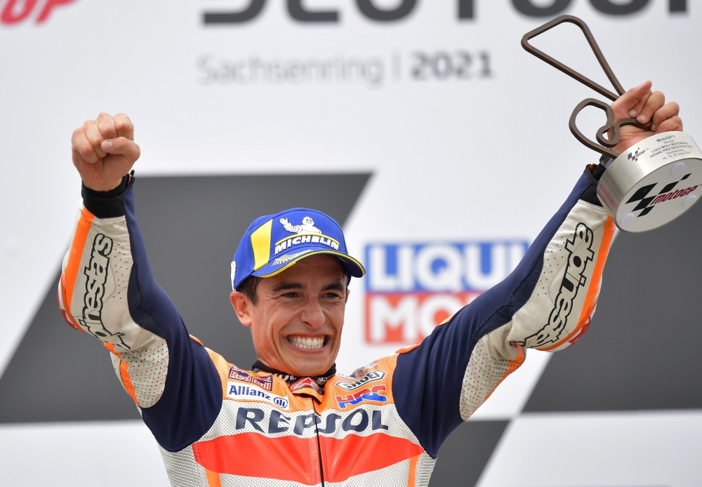 Repsol Honda's Marc Marquez celebrates with a trophy on the podium after winning the race REUTERS/Matthias Rietschel