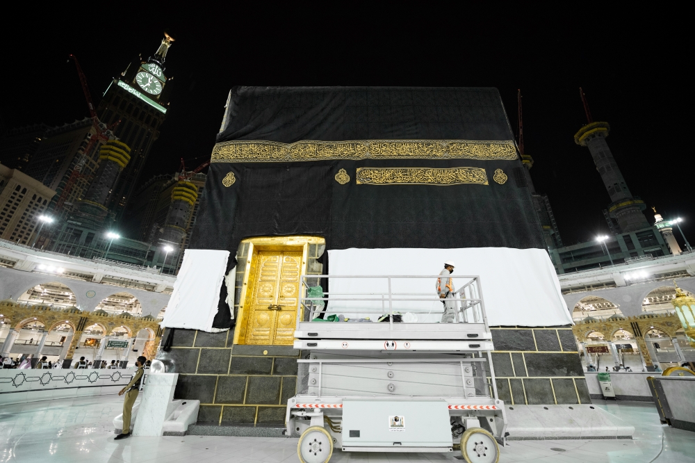 Officials replace the new covering cloth of the holy Kaaba (Kiswa) during the annual Haj pilgrimage, in the holy city of Mecca, Saudi Arabia, July 18, 2021. Saudi Ministry of Media/Handout via REUTERS