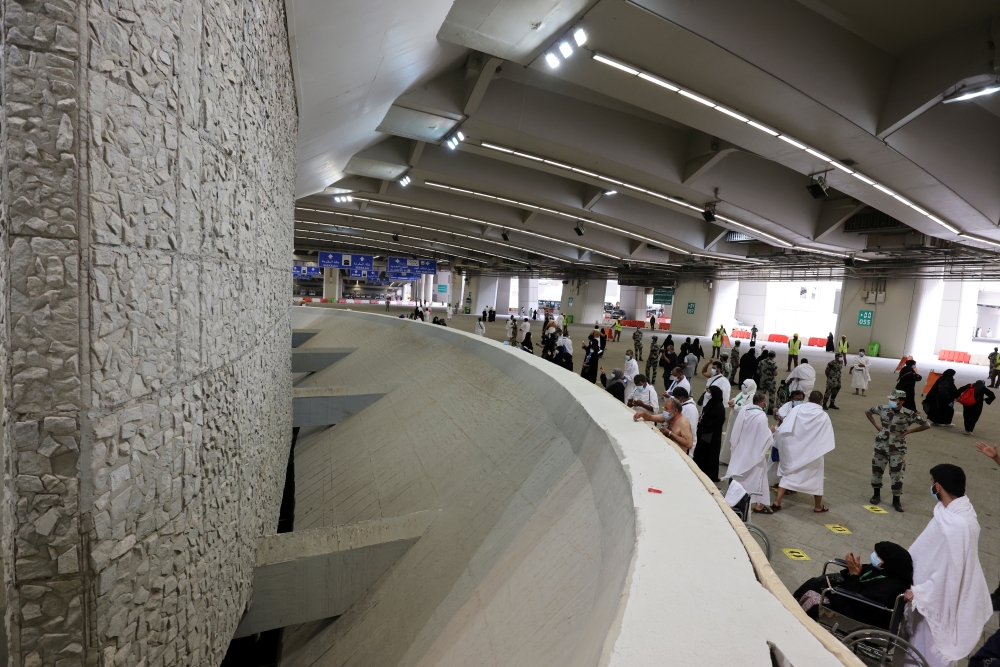 Pilgrims cast stones at pillars symbolizing Satan during the annual Haj pilgrimage, amid the coronavirus disease (COVID-19) pandemic, in Mina, near the holy city of Mecca, Saudi Arabia, July 20, 2021. (REUTERS/Ahmed Yosri)