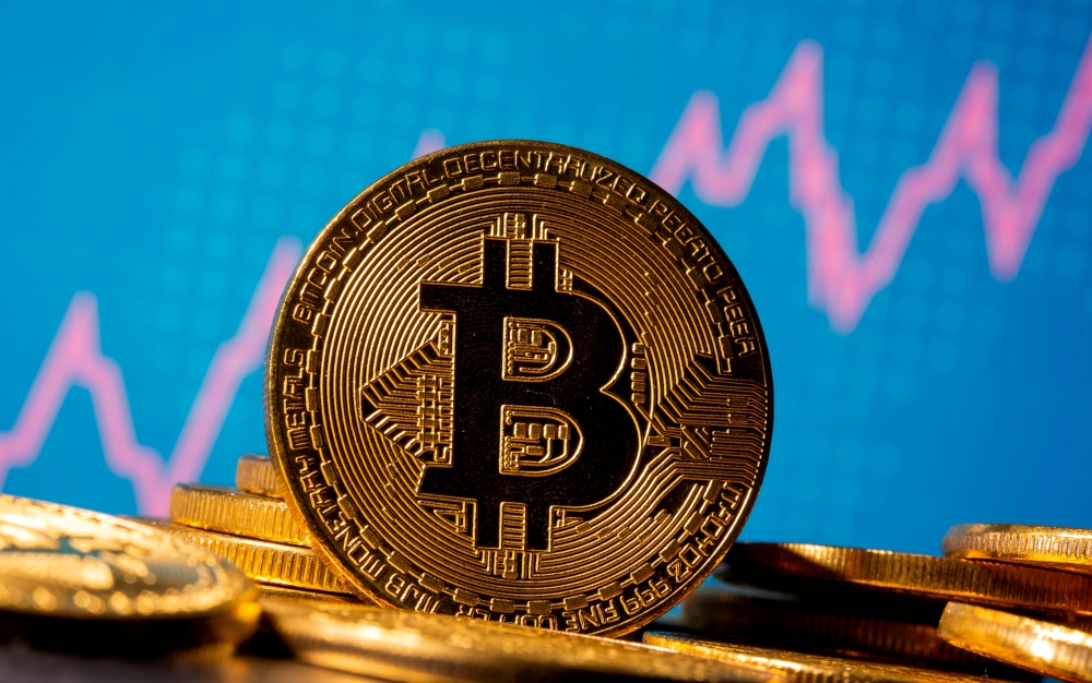 A representation of virtual currency bitcoin is seen in front of a stock graph in this illustration taken November 19, 2020. REUTERS/Dado Ruvic/Illustration/File Photo