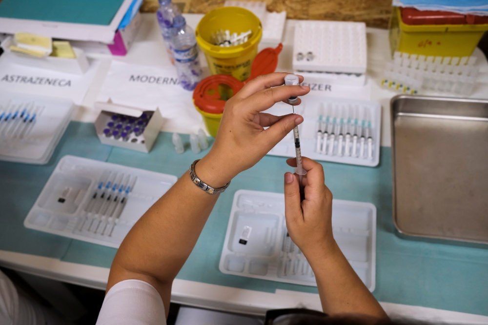 A healthcare worker prepares a dose of the Pfizer coronavirus disease (COVID-19) vaccine at a vaccination centre in Seixal, Portugal, September 11, 2021. Picture taken September 11, 2021. REUTERS/Pedro Nunes