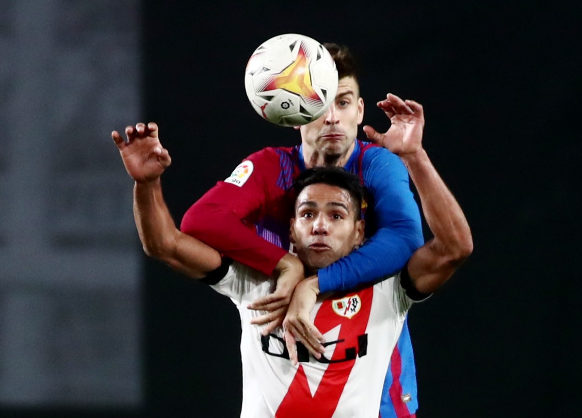 Rayo Vallecano's Radamel Falcao in action with FC Barcelona's Gerard Pique REUTERS/Sergio Perez