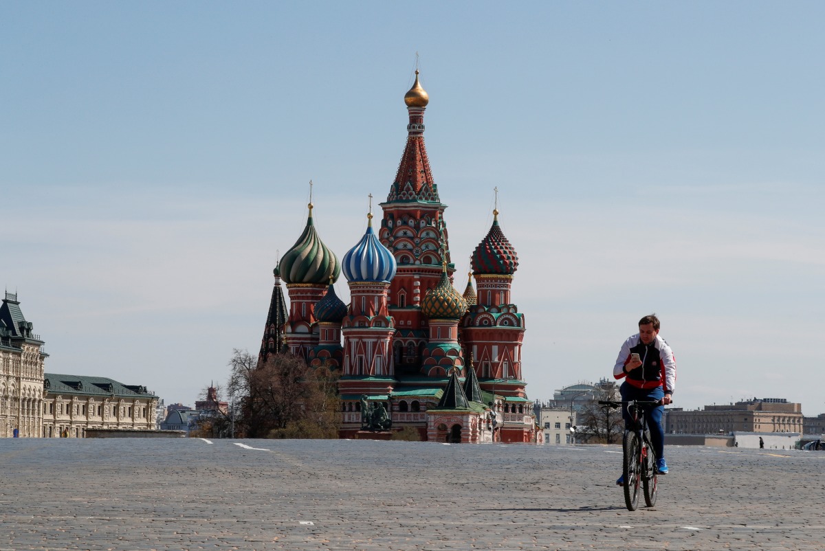 FILE PHOTO: A man rides a bicycle along empty Red Square near St. Basil's Cathedral in central Moscow, Russia May 1, 2020. REUTERS/Shamil Zhumatov/File Photo