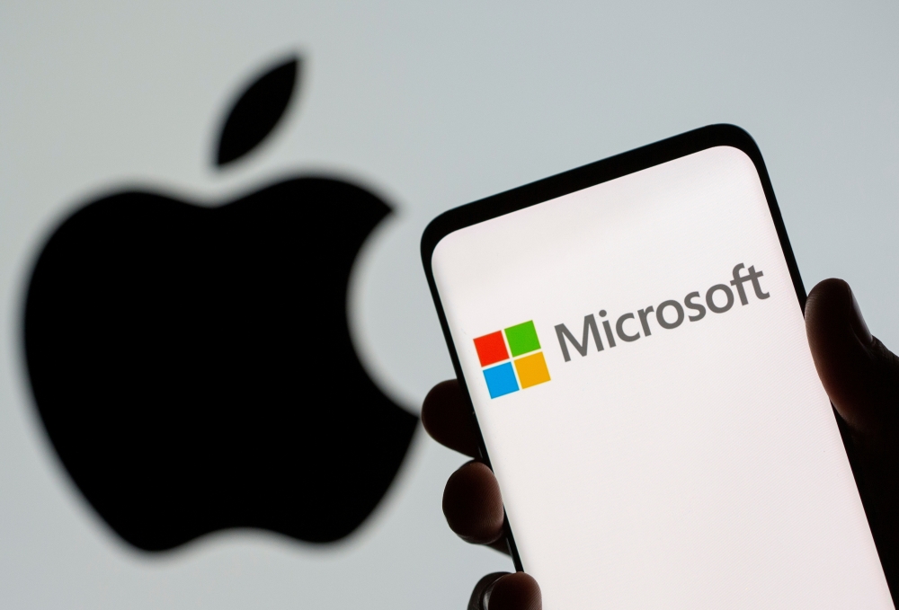 Microsoft logo is seen on the smartphone in front of displayed Apple logo in this illustration taken, July 26, 2021. REUTERS/Dado Ruvic/Illustration/File Photo