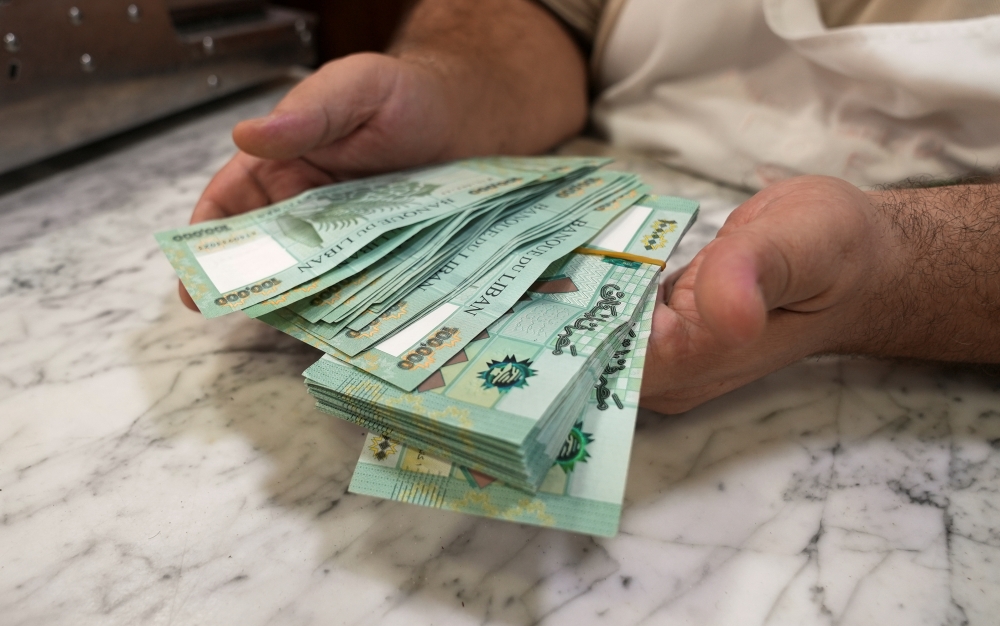 Antoine Haddad, known as Abou Chadi, a Lebanese restaurant owner, holds Lebanese pound banknotes in Jal el-Dib, Lebanon October 26, 2021. Picture taken October 26, 2021. REUTERS/Issam Abdallah