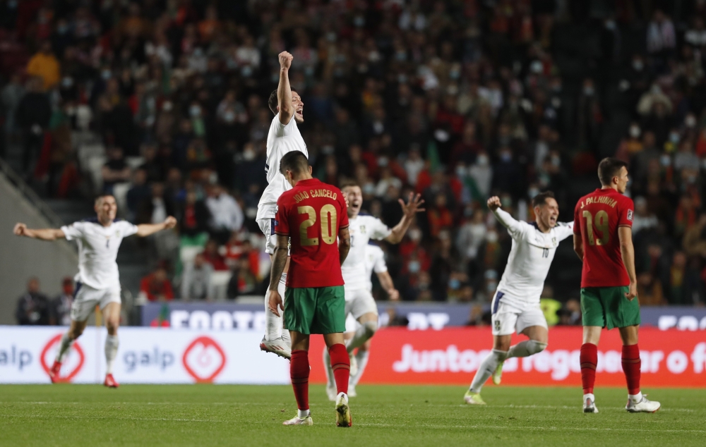 Portugal's Joao Cancelo looks dejected as Serbia players celebrate after winning the match and qualifying for the Qatar 2022 World Cup... Reuters/Pedro Nunes