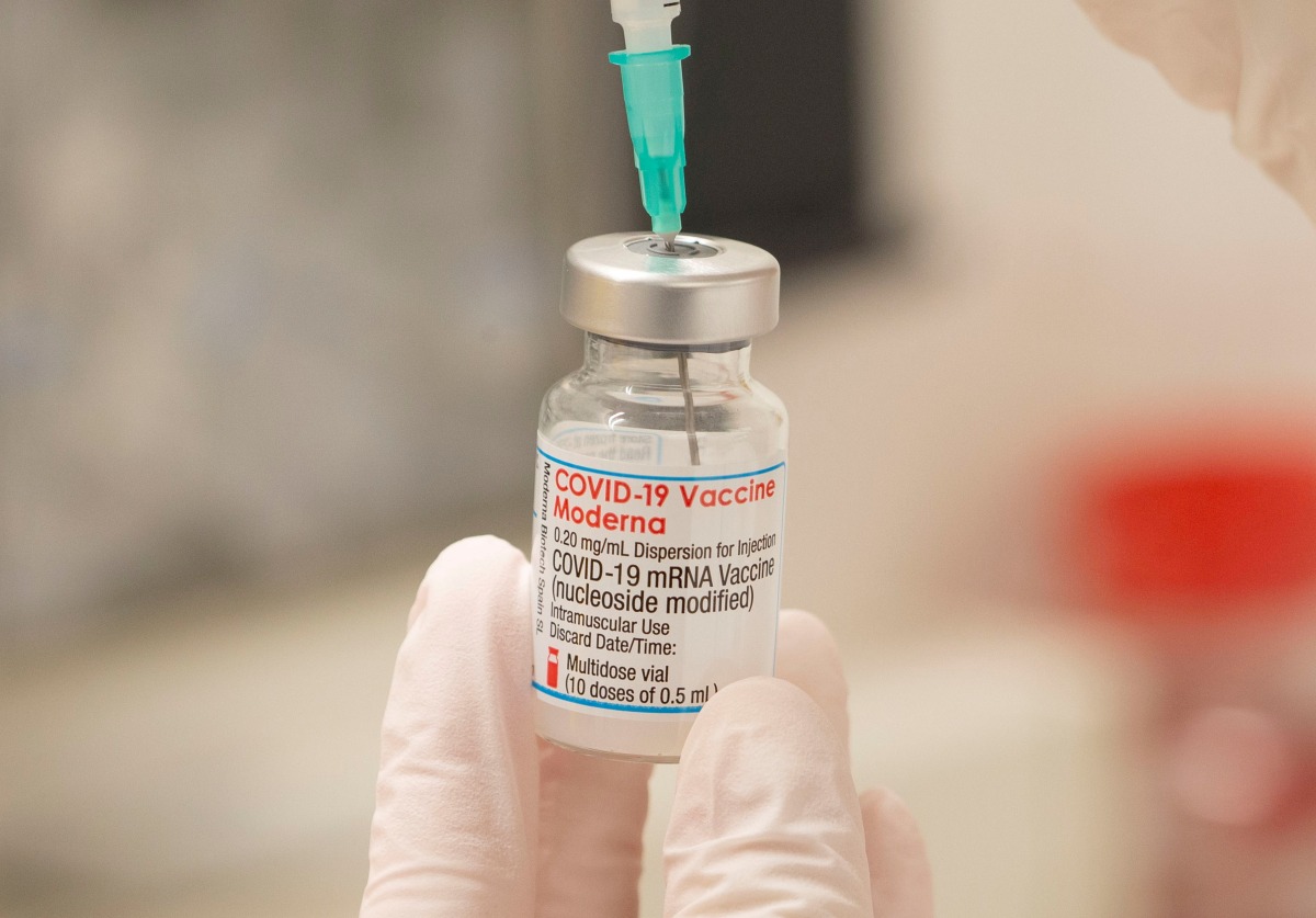 FILE PHOTO: A health care worker fills up a syringe with a dose of Moderna's COVID-19 vaccine for a booster shot at the vaccination reference center at the Epidemiology, Biostatistics and Prevention Institute (EBPI) in Zurich, Switzerland November 17, 2021. REUTERS/Arnd Wiegmann/File Photo
