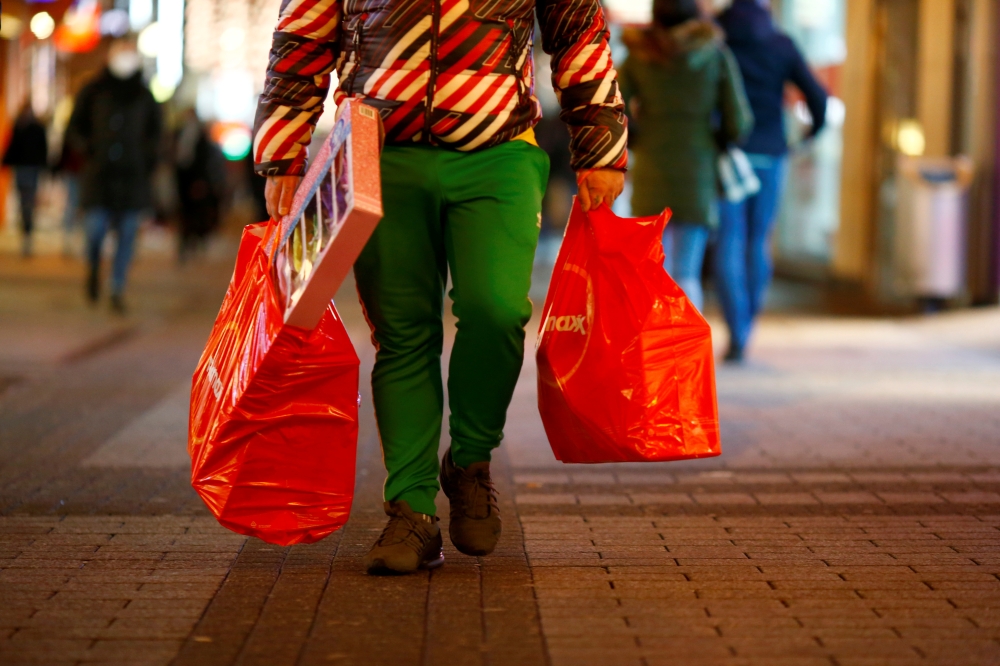 A man carries bags on Hohe Strasse shopping street as the spread of the coronavirus disease (COVID-19) continues in Cologne, Germany, December 1, 2021. REUTERS